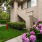 a building with a staircase and flowers and bushes in front of it
