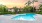 a swimming pool with palm trees and buildings in the background